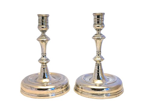 A pair of silver candle holders with feet. Around 
1750