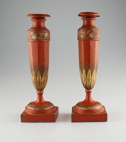 A pair of red candle holders with gildings