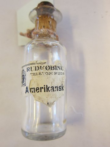 For samleren:
Gammel apotekerflaske fra Rudkøbing
"Amerikansk" (olie?) 
Vi har et godt udvalg af gamle apotekerflasker samt et stort udvalg af gamle 
købmandsvarer med originalt indhold