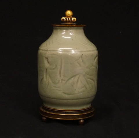 Royal Copenhagen: A lidded jar by Jais Nielsen, 
1885-1961, celadon glaze. Lid and stand of 
patinated and partly gilded bronze by Knud 
Andersen. H: 21cm