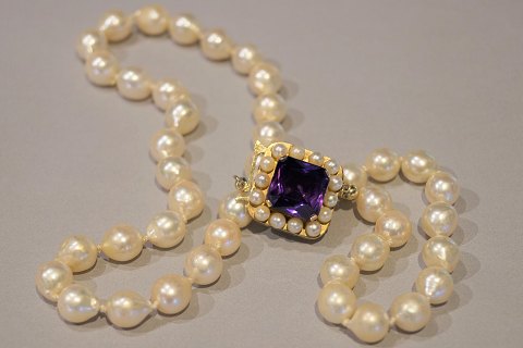 A pearl chain with cultured pearls, gold clasp with an amethyst