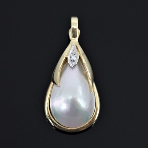 A pendant of 14k gold and white gold set with a mabé pearl and diamond
