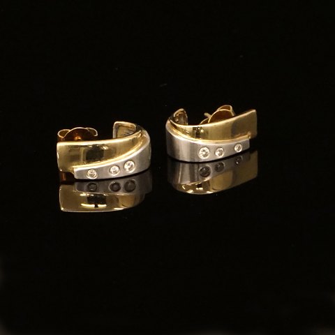 A pair of 14kt gold earrings each with three 
diamonds of circa 0,04ct. Size: 14x6mm