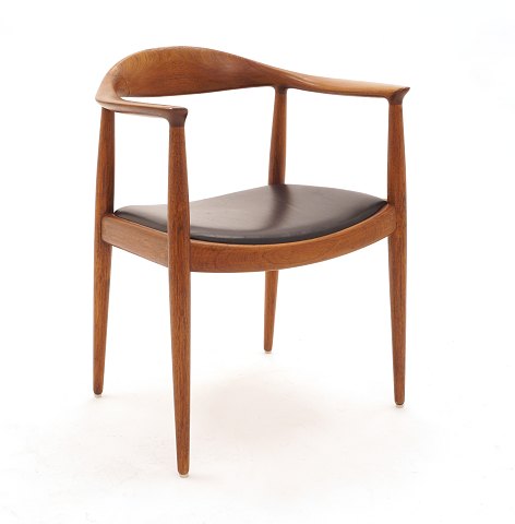 Hans J. Wegner, 1914-2007: The Chair, Teak. 
Reparierte Bruchstelle am Rücken. Der Stuhl ist 
stabil und eignet sich als Gebrauchsgegenstand. 
Sitz mit schwarzem Leder