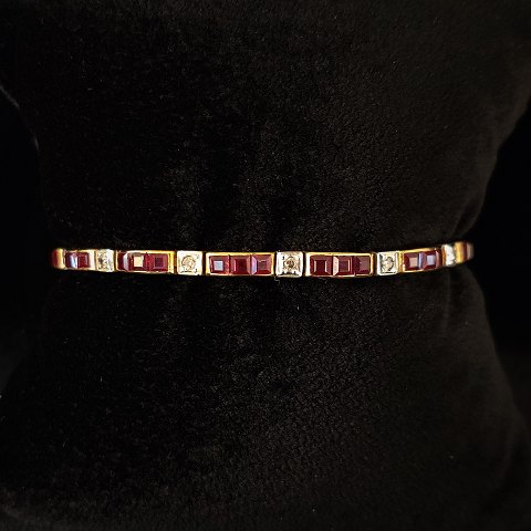A gold bracelet set with Carré-cut rubies and brillants