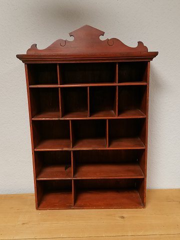Red painted shelf with 14 compartments