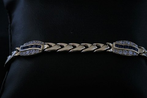 Gold bracelet with inlaid swarovski stones and blue sapphire in 14 carat gold, 
with box lock