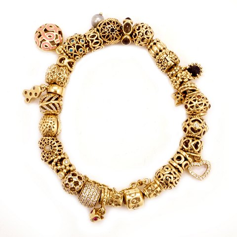Pandora gold bracelet with 26 charms. W: 79,7gr