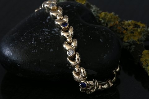 Elegant and classic gold bracelet in 14 carat gold, with inlaid stones and box 
lock.