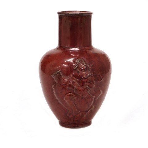 Vase med okseblodsglasur prydet med religiøse 
motiver i relief fremstillet af Jais Nielsen for 
Royal Copenhagen  modelnummer 20247. H: 23cm