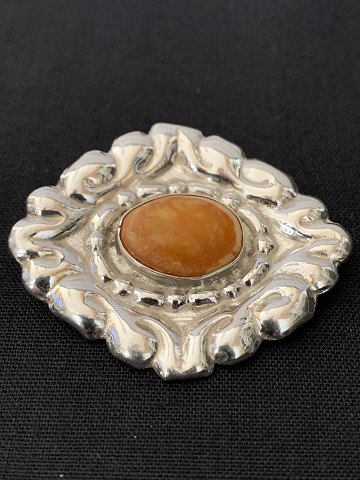 Silver brooch in 830 silver, with inlaid amber in the middle of the brooch.
