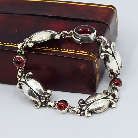 Georg Jensen; A "Moonlight Blossom" bracelet of sterling silver, set with granates, No. 11
