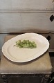 Large oval platter with wavy edge in old earthenware with a very fine patina.