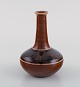 Kähler, HAK. Narrow neck vase in glazed ceramics. Geometric pattern on brown 
background. 1940s.

