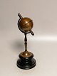 Patinated brass money box in the form of a globe on a wooden base