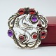 Georg Jensen; 
Silver brooch 
with granates 
and amethyst, 
...