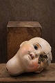 Old doll head 
in painted 
papier-mâché...