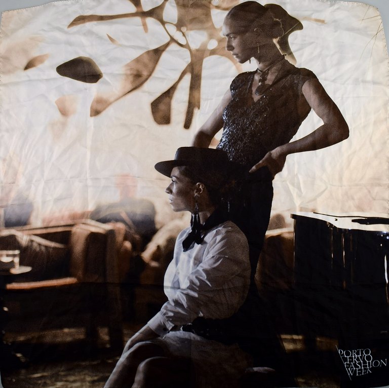 Porto Cervo Fashion Week, scarf with two women in bar interior.
