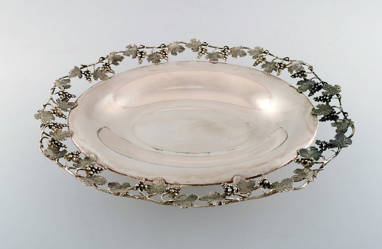 Large silver bowl pierced with grape vines.
