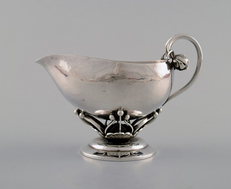 Georg Jensen: Pitcher of sterling silver, forged with flower buds and pierced 
stem with leaves.