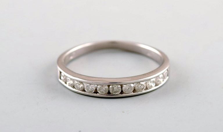 Classic alliance ring in 10 carat white gold with numerous diamonds.
