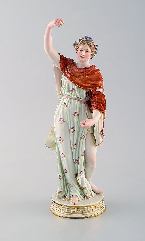 Meissen porcelain figurine. Woman in colorful dress with floral wreath in her 
hair. Ca. 1900.