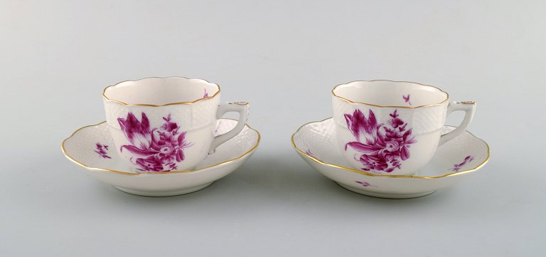 To Herend kaffekopper med underkop i håndmalet porcelæn. Lilla blomster og 
gulddekoration. 1950