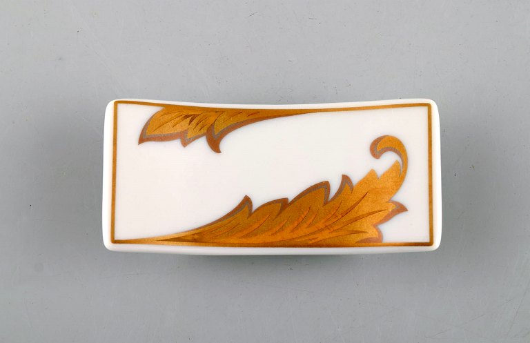 Gianni Versace for Rosenthal. "Arabesque Gold" porcelain knife rest with gold 
decoration. Late 20th century.
