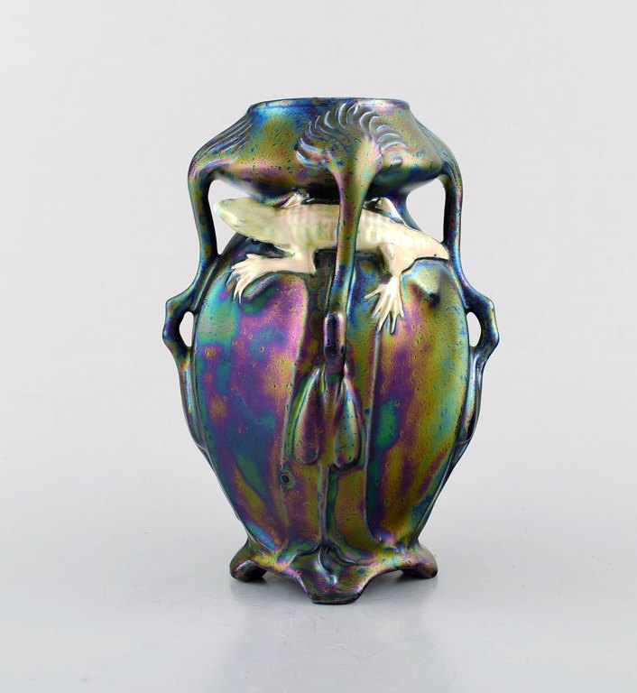 Vilmos Zsolnay for Zsolnay. Sjælden art nouveau vase på fødder i eozin glasur 
med salamander i perlemorsglasur. Museumskvalitet.
Sent 1800-tallet.
Måler: 18 x 12,5 cm.
I flot stand.
Utydeligt stempel. Modelnummer svært at læse.