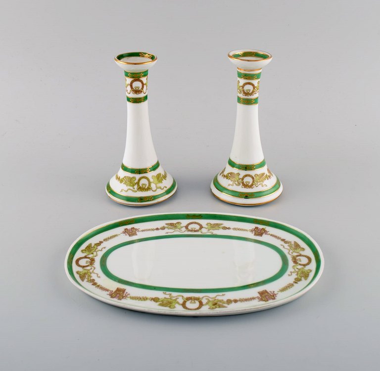 Limoges, Frankrig. To lysestager og et fad i håndmalet porcelæn med grøn kant og 
gulddekoration. 1930/40