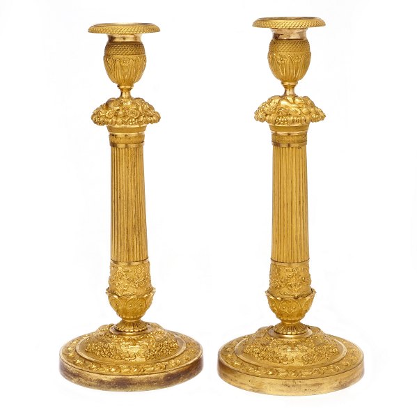 Par lueforgyldte bronze lysestager med kannelerede stammer. Rigt dekoreret med 
stiliserede blomster og bladværk. Frankrig ca. år 1820. H: 34cm